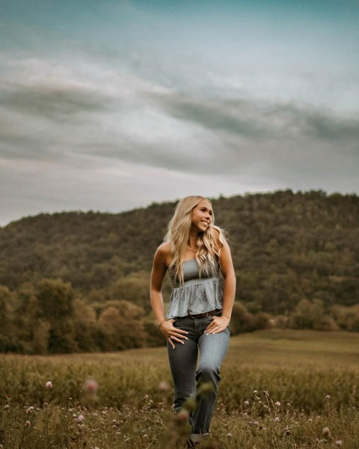 a woman standing in the middle of a field