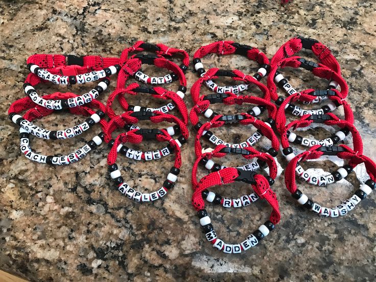 a bunch of red and black bracelets sitting on top of a granite countertop