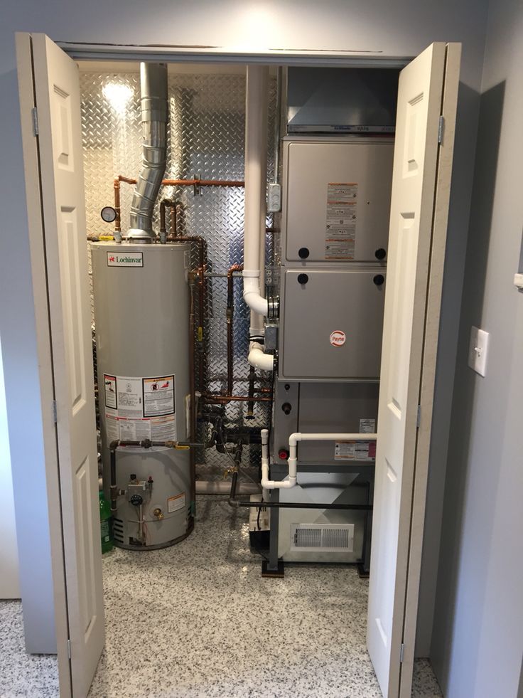 an open door leading to a room with two hot water heaters and other equipment