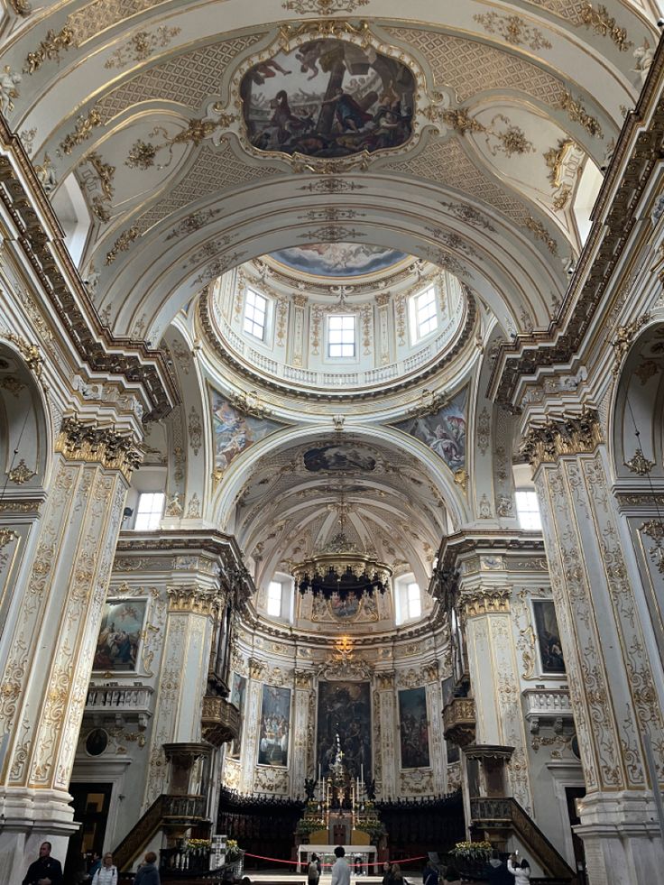 the inside of a church with people walking around