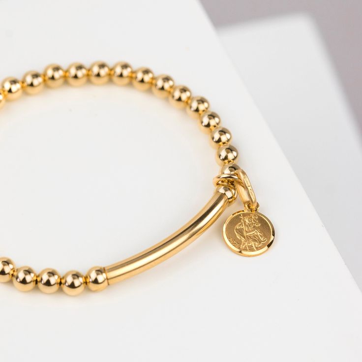 Our 14ct gold filled St Christopher bracelet is a beautiful gift for a special someone, a birthday or for someone off on a big journey!  The bracelet is a stretch bracelet, so no fiddly clasps and comes with a teeny tiny circular 9ct solid gold St Christopher pendant. Available with an optionally added pendant which we engrave with your chosen message (up to 25 chars.) - this bracelet makes a gorgeously personalised gift, no matter who it's for. It is a delightful idea for a graduation gift, the Gold Charm Bracelet Gift, Gift 14k Yellow Gold Bracelet, 14k Yellow Gold Bracelet Gift, Rose Gold Charm Bracelet As A Gift, Rose Gold Charm Bracelet For Gift, Gold Charm Bracelet Tarnish Resistant For Gift, Yellow Gold Charm Bracelet For Gift, Classic Yellow Gold Charm Bracelet For Gift, Classic Yellow Gold Charm Bracelet As Gift