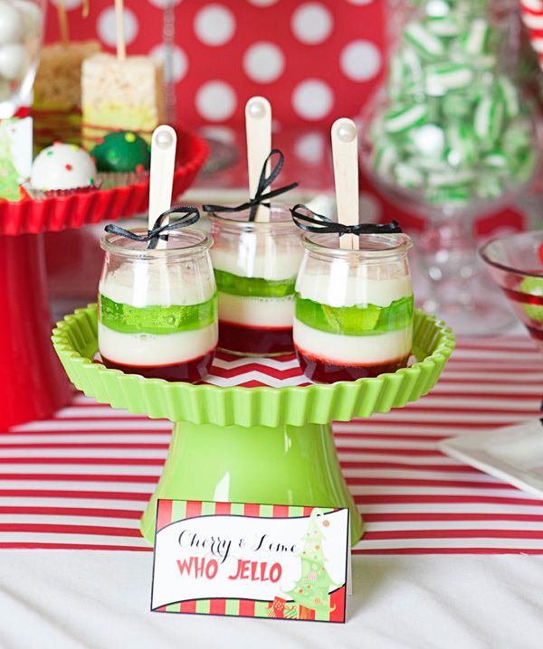 desserts are displayed in small glass jars on a red and white tableclothed table