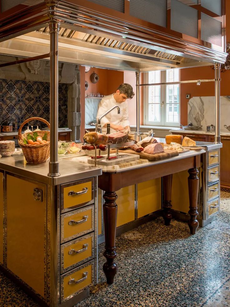 a chef preparing food in a kitchen with lots of counter space and yellow cabinetry