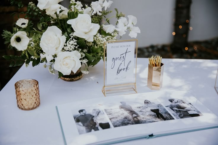 a table topped with white flowers and photos