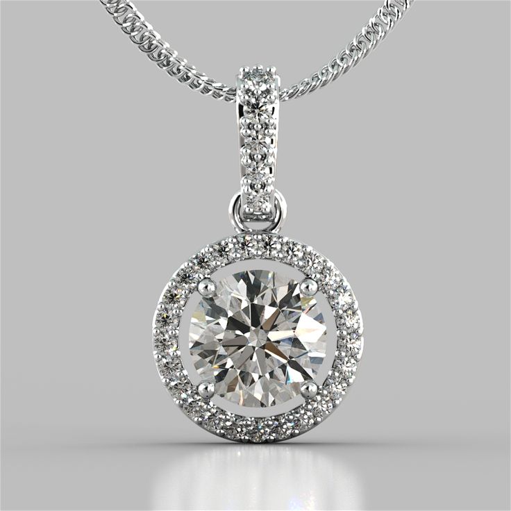 Give the gift of timeless elegance with this beautiful pendant. A breathtaking Simulated Diamond halo gracefully holds a brilliant center stone. Exquisitely made in 925 Sterling Silver, the Pendant features a bail slide amidst additional simulated diamonds to add an extra pop of sparkle. Classy and chic, this is sure to please the goddess in your life. Round Cut Embelished Bail and Halo Pendant Center Stone: 2 CT Total Carat Weight: 2.33 CTW Stone Clarity: VVS-1 Precious Metal:925 Sterling Silver 16" Chain in 925 Sterling Silver Included Model: PD2502-WH-SL Memorable Jewelry, Jewelry Rendering, Diamond Pendant Sets, Diamond Solitaire Necklace, Halo Pendant, Solitaire Necklaces, Solitaire Pendant, Diamond Pendant Necklace, Diamond Design