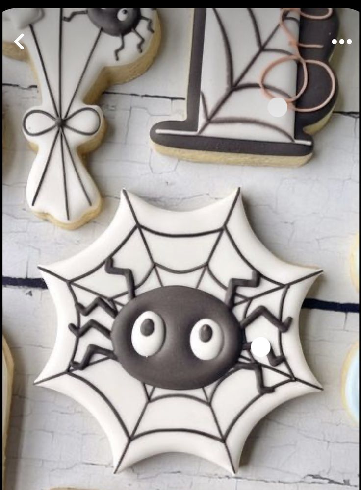 decorated cookies with eyes and spider webs on the top one is black and white