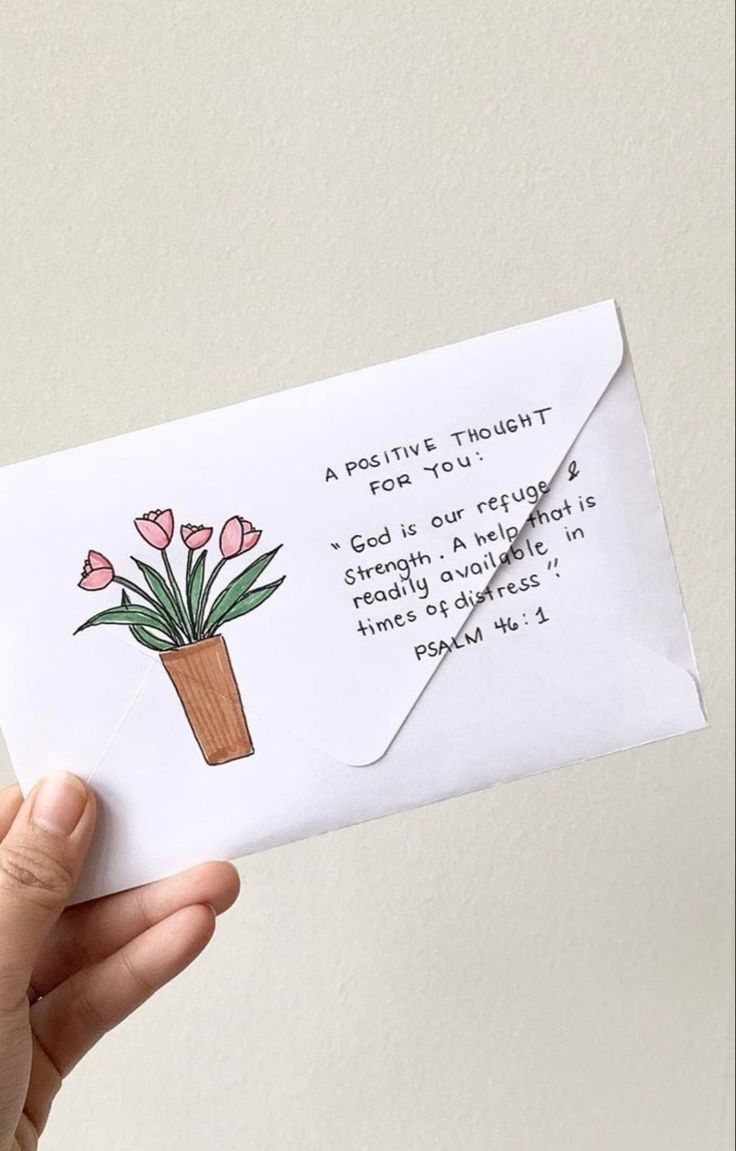 a hand holding an envelope with flowers in it and a poem written on the envelope