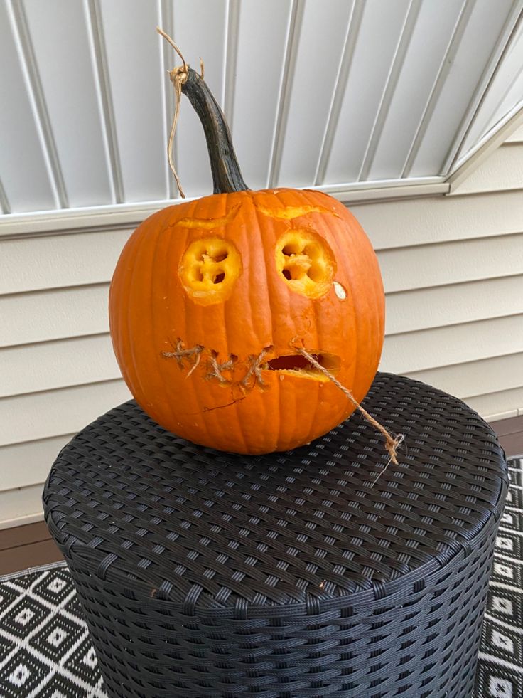 a carved pumpkin sitting on top of a wicker basket