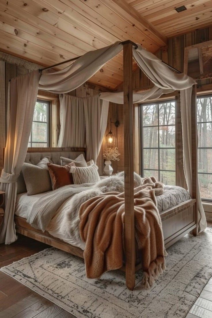 a large bed sitting inside of a bedroom next to two windows and a rug on the floor