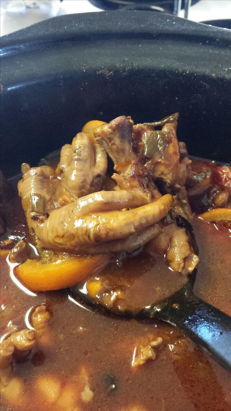 the food is being cooked in the slow cooker with tongs, and ready to be eaten