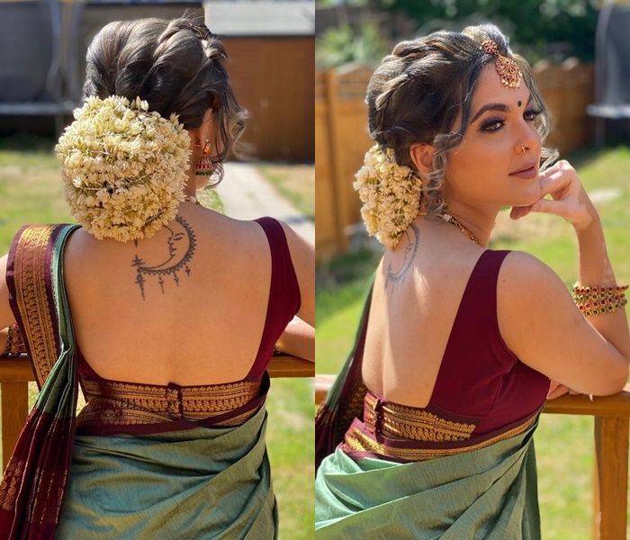 a woman in a green sari sitting on a chair with her back to the camera