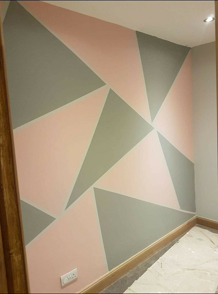 an empty room with pink, grey and white walls