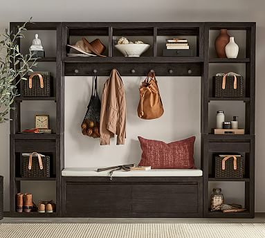 a wooden bench sitting under a shelf filled with bags