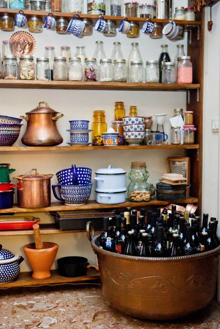 an old kitchen with lots of pots and pans on the shelves next to each other