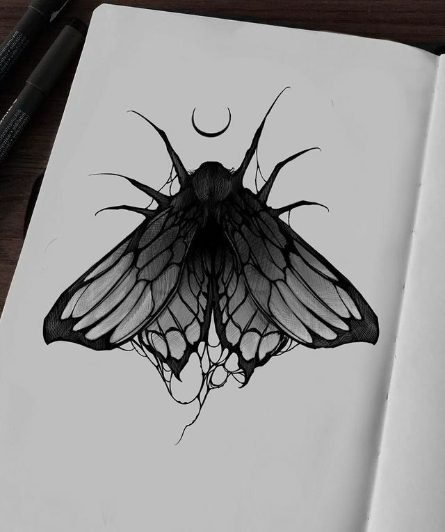 a black and white drawing of a butterfly on a notebook with a pen next to it