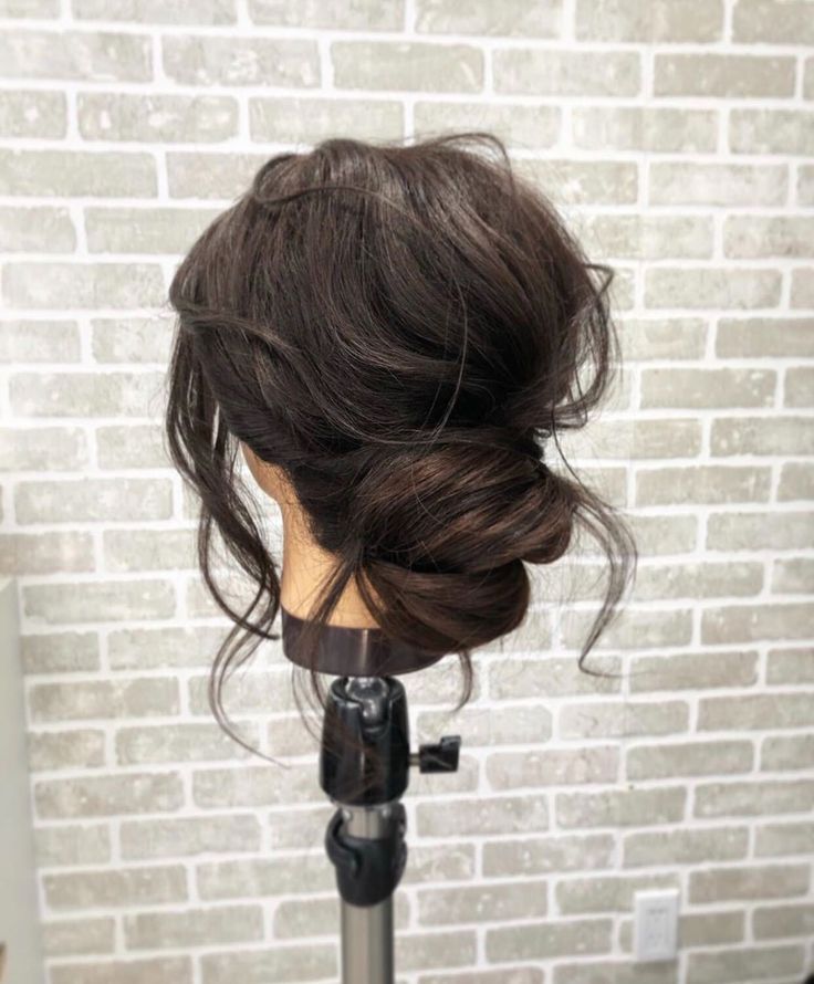 a woman's head is shown on a tripod in front of a brick wall