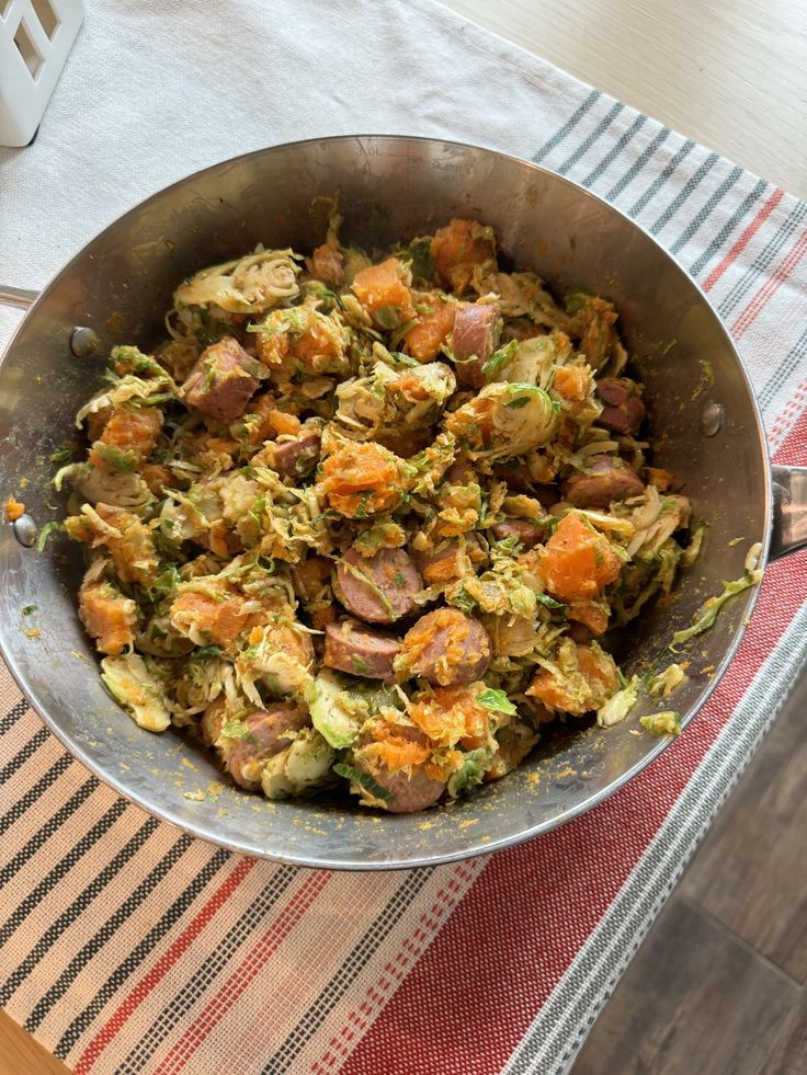 a metal bowl filled with food on top of a table