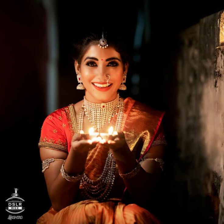 a woman holding a lit candle in her hands