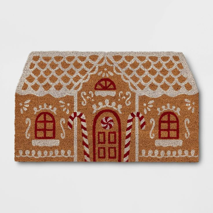 a gingerbread house door mat with candy canes on the front and side panels