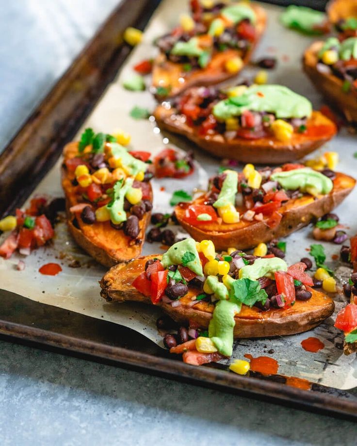 baked sweet potatoes topped with guacamole and black beans