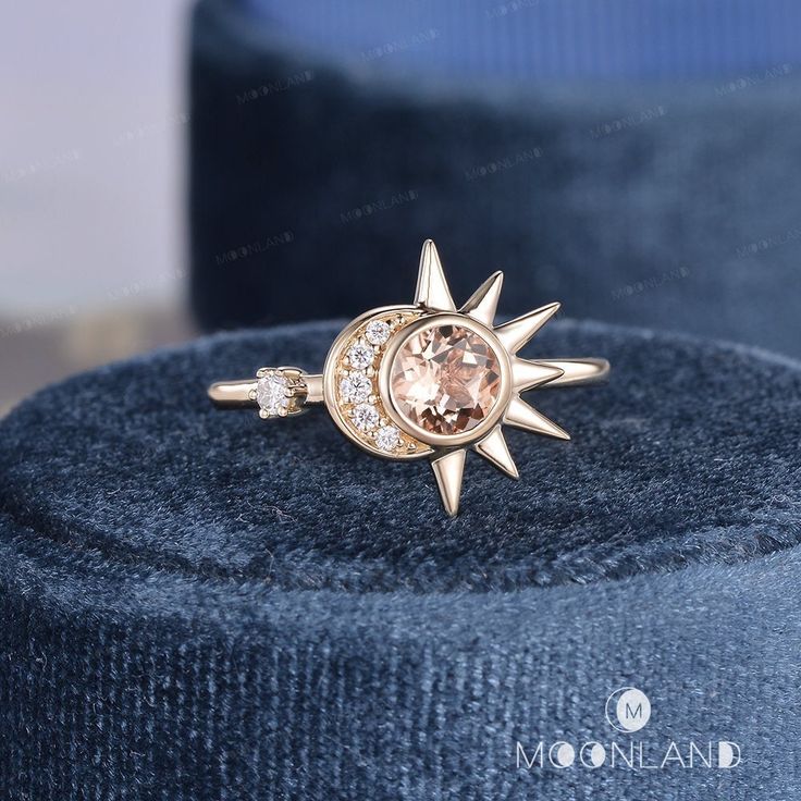 the sun and moon ring is sitting on top of a blue velvet cushioned box