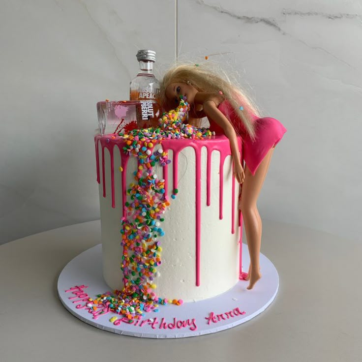 a barbie doll standing on top of a birthday cake covered in sprinkles