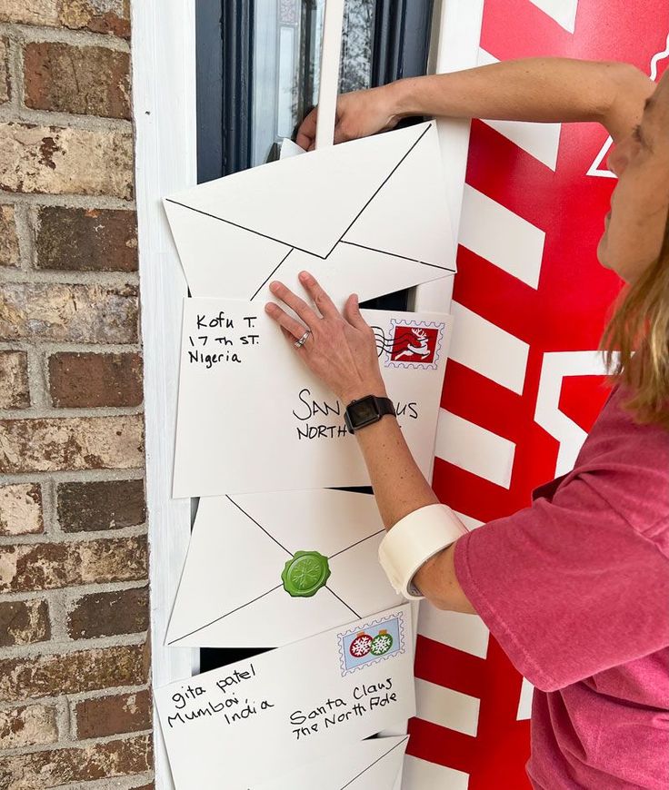 a woman is writing on the side of a door with her hand and stamping