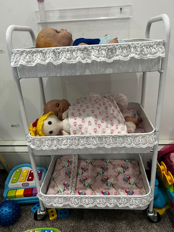 three tiered baby changing table with stuffed animals and toys on the bottom shelf next to it