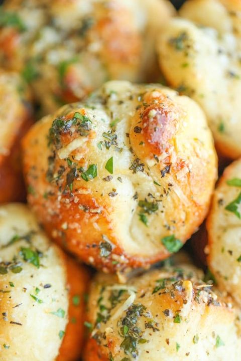 close up view of baked breads with herbs on them and seasoning sprinkled on top