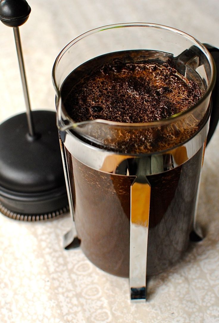 a blender filled with brown liquid on top of a white tablecloth covered floor