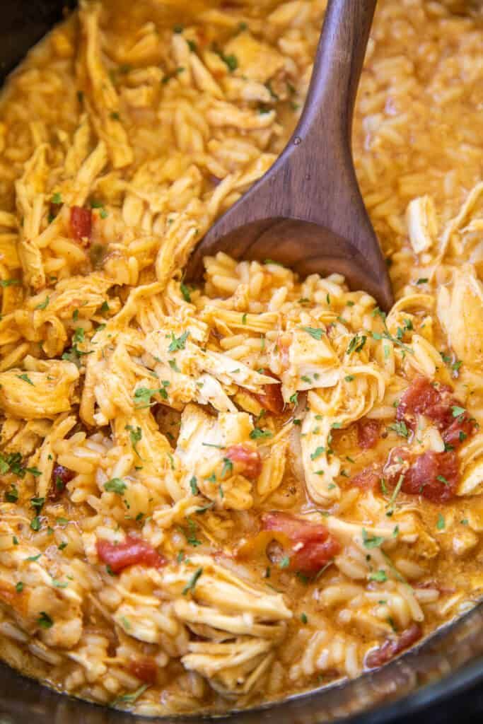 a wooden spoon in a pot filled with pasta