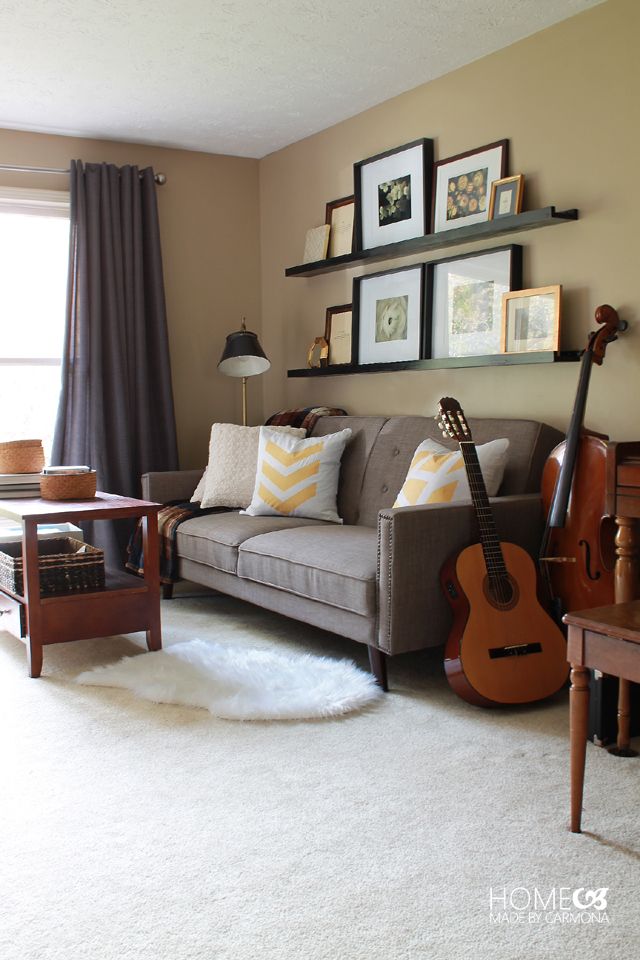 a living room with a couch, guitar and coffee table in front of the window