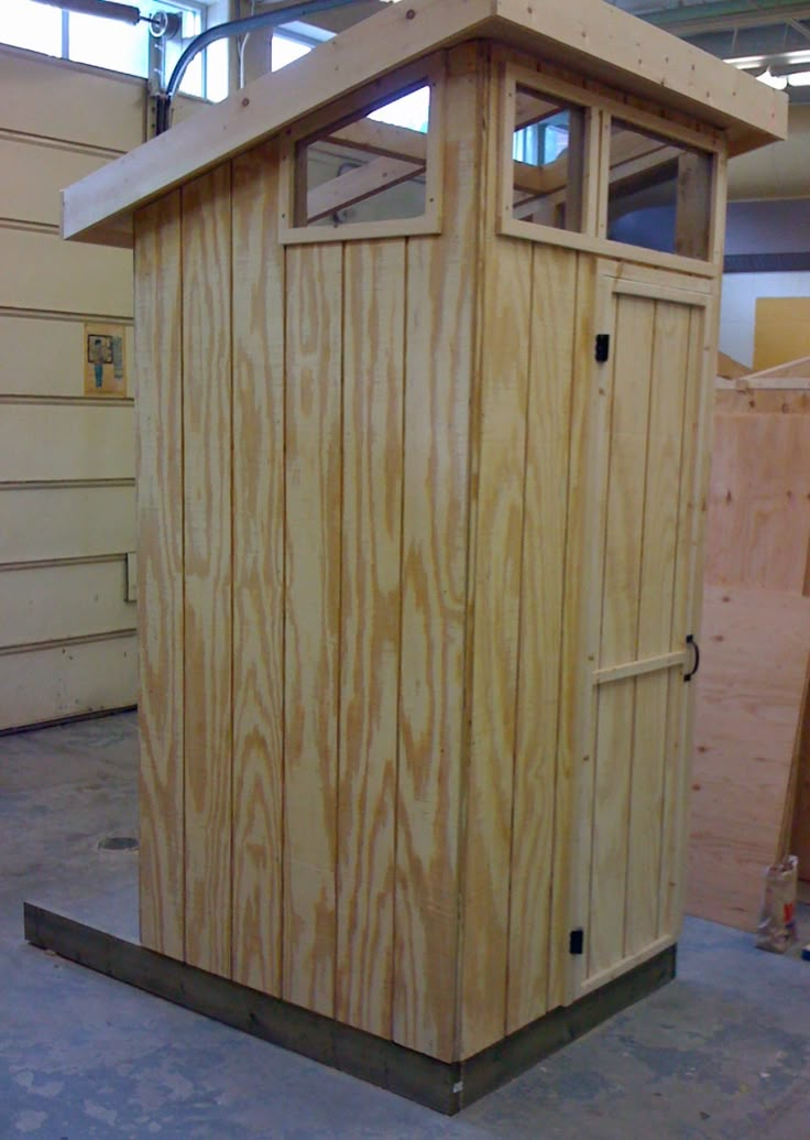 a small wooden outhouse sitting inside of a building