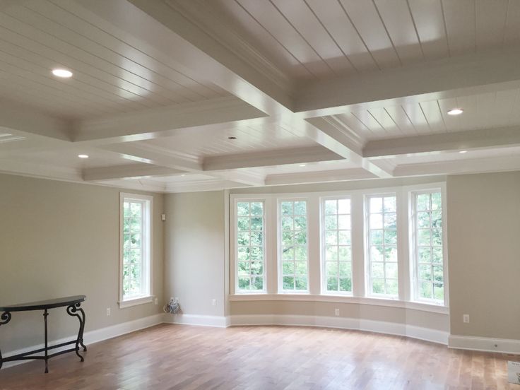 an empty living room with hard wood floors and white walls, windows in the ceiling