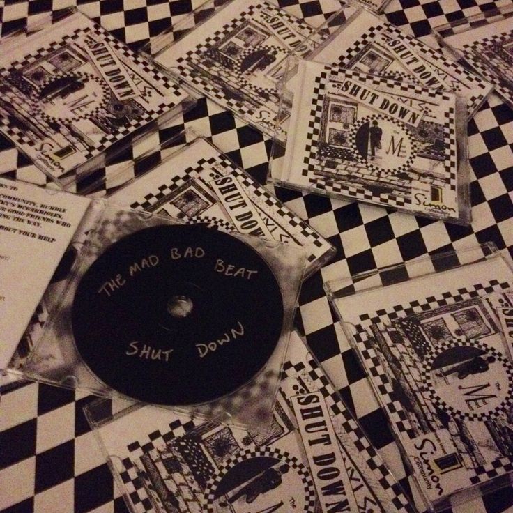 the cd cover is laying on top of some black and white checkered papers