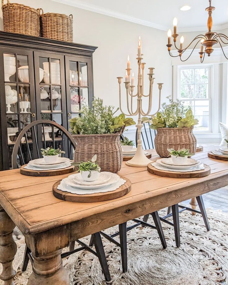 a dining room table with place settings on it and candles in the centerpieces