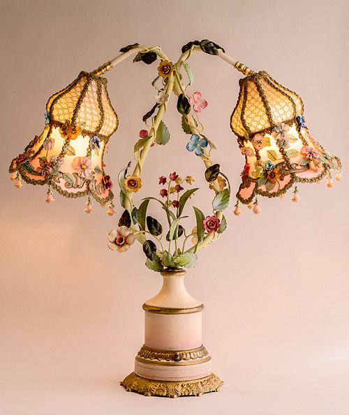 a table lamp with three lamps on top of it and some flowers in the middle