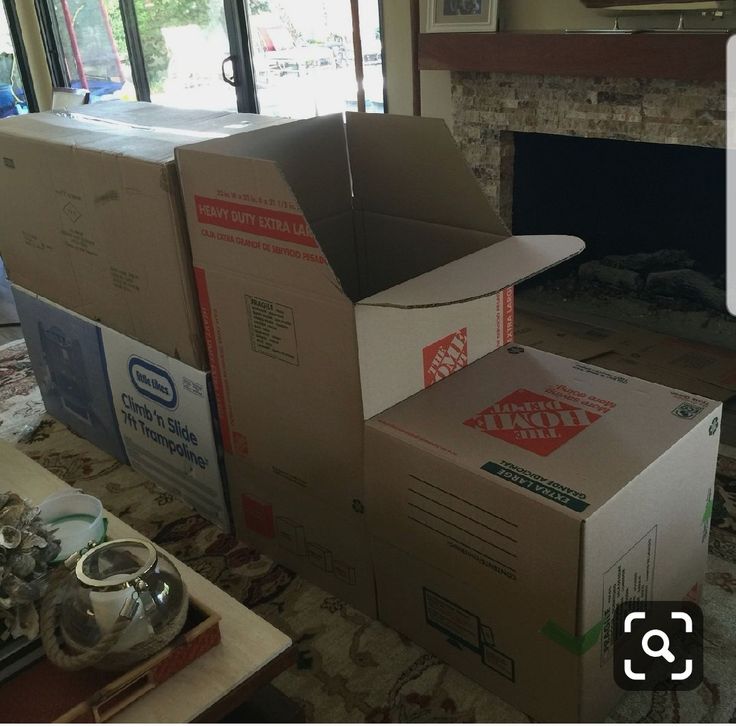 two boxes stacked on top of each other in front of a fire place with windows