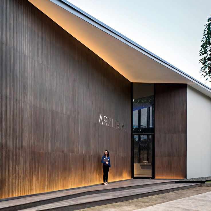 the entrance to an art gallery with large wooden doors and steps leading up to it