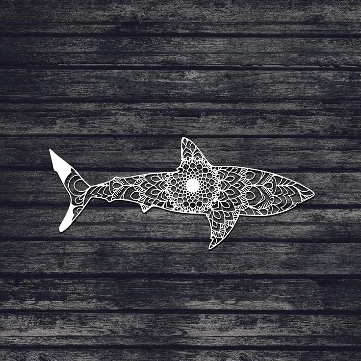 a drawing of a shark on a wooden surface with an intricate design in the middle