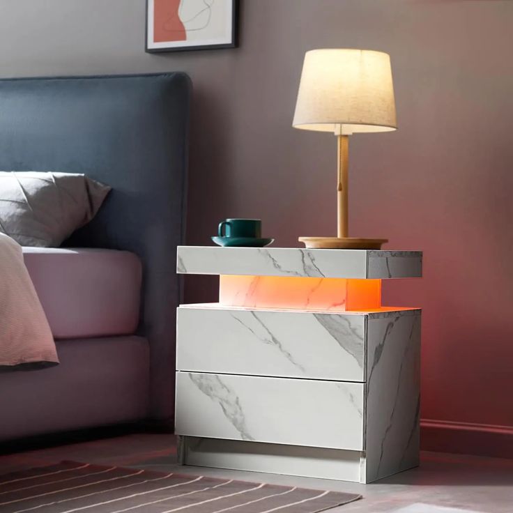 a white marble night stand next to a bed