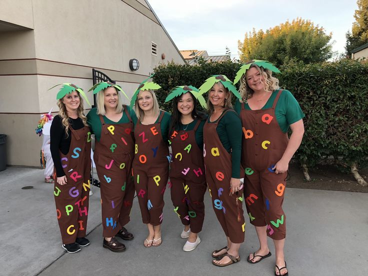 group of women dressed in costumes with letters painted on them