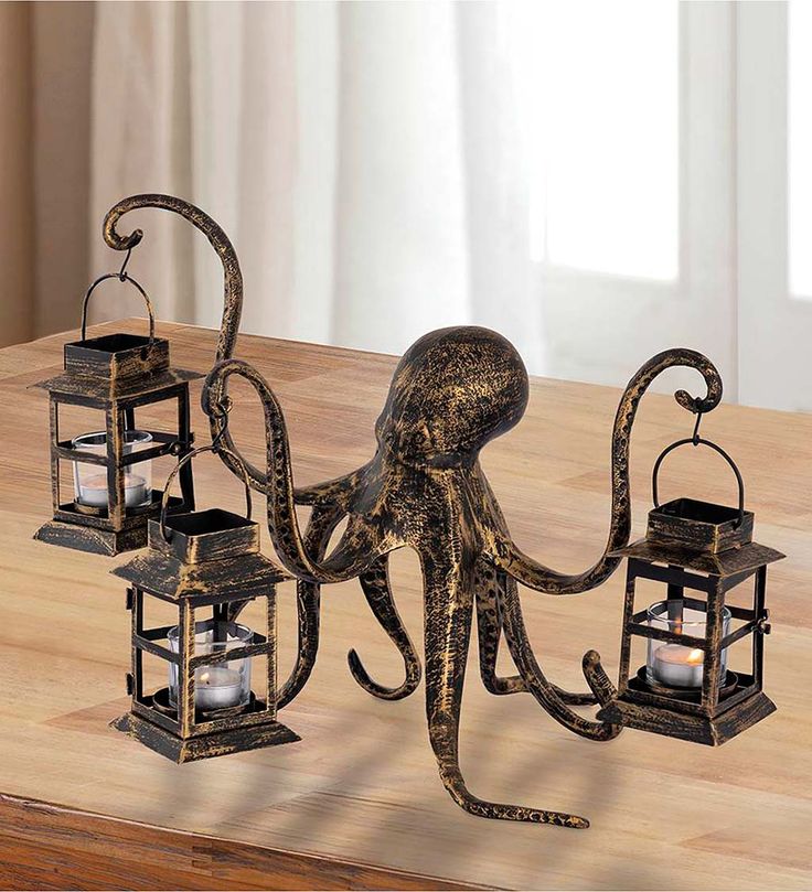 an octopus statue holding three lanterns on a table