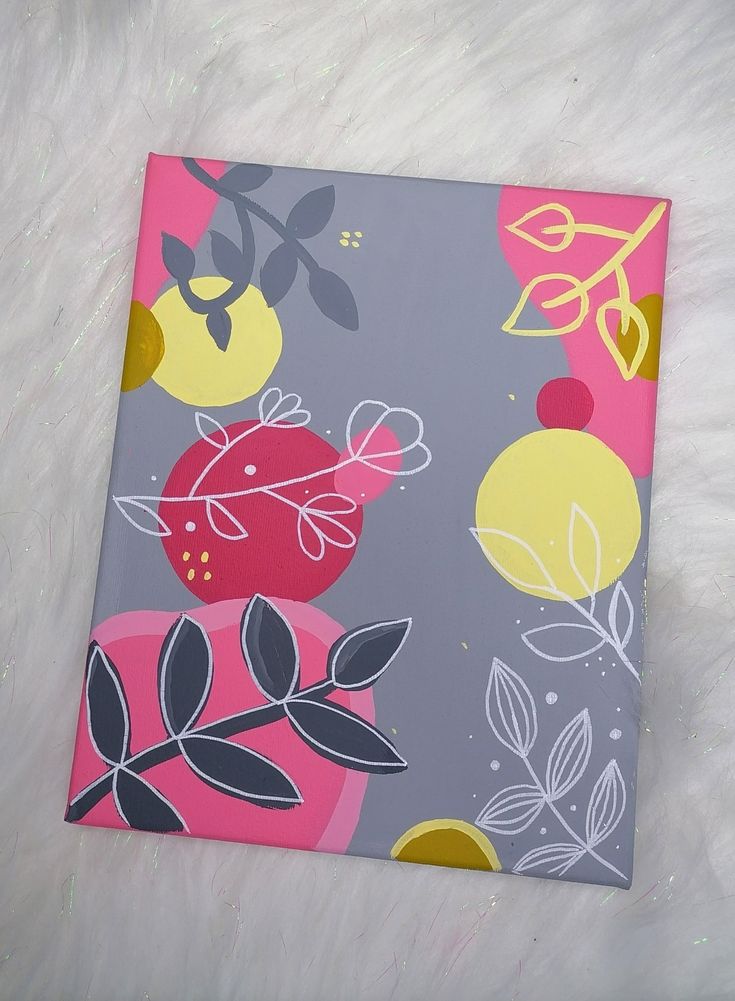 a square painting with flowers and leaves on it