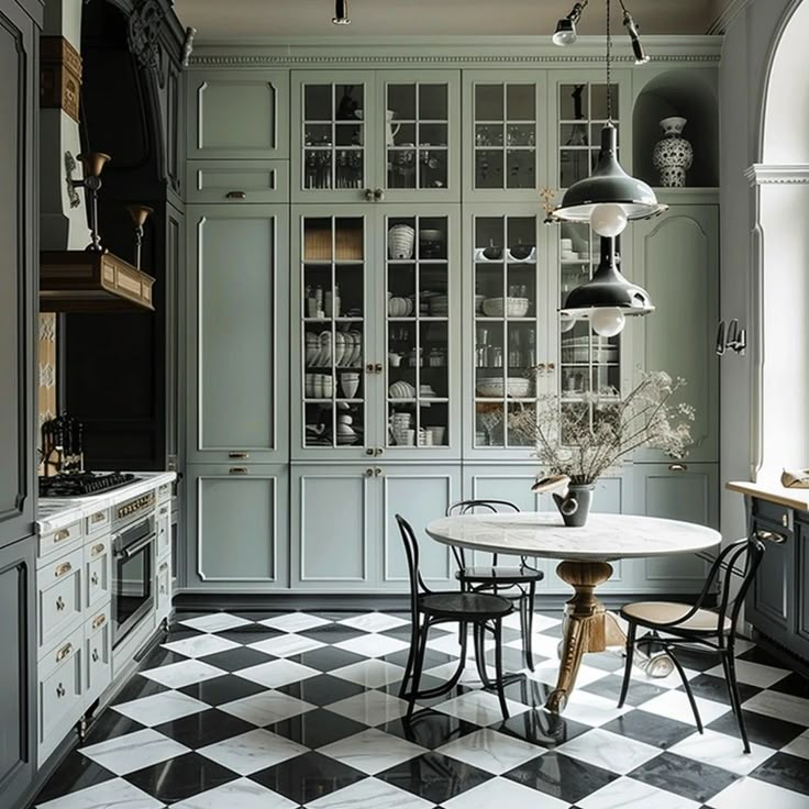 a kitchen with black and white checkered flooring, cabinets and table in the center