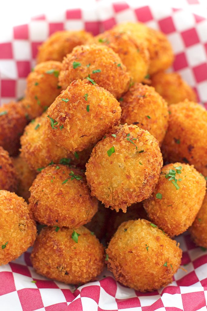 a pile of fried food sitting on top of a red and white checkered table cloth