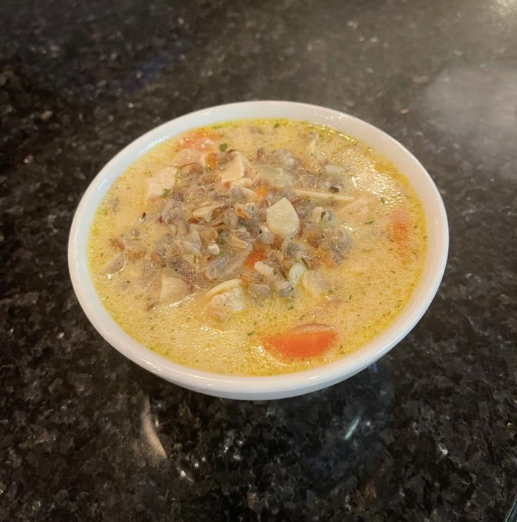 a white bowl filled with soup sitting on top of a counter