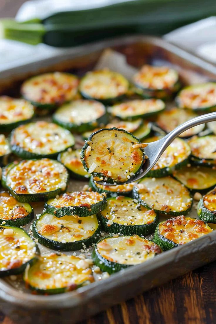 a pan filled with cooked zucchini on top of a wooden table