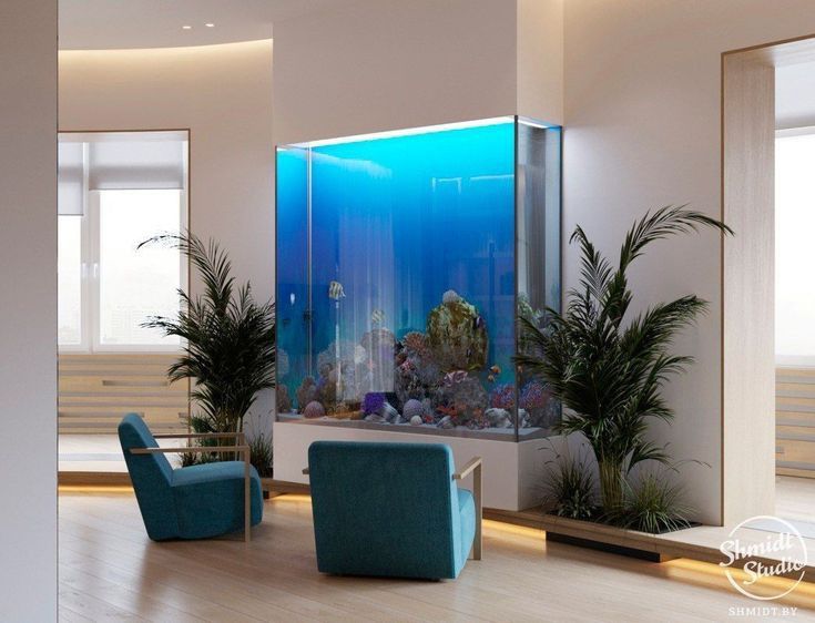 a fish tank in the middle of a living room with two chairs and a couch