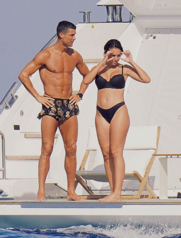 a man and woman standing on the deck of a boat